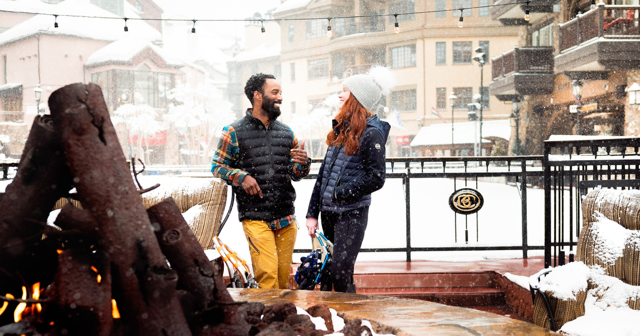 a couple laughing standing next to the ice rink